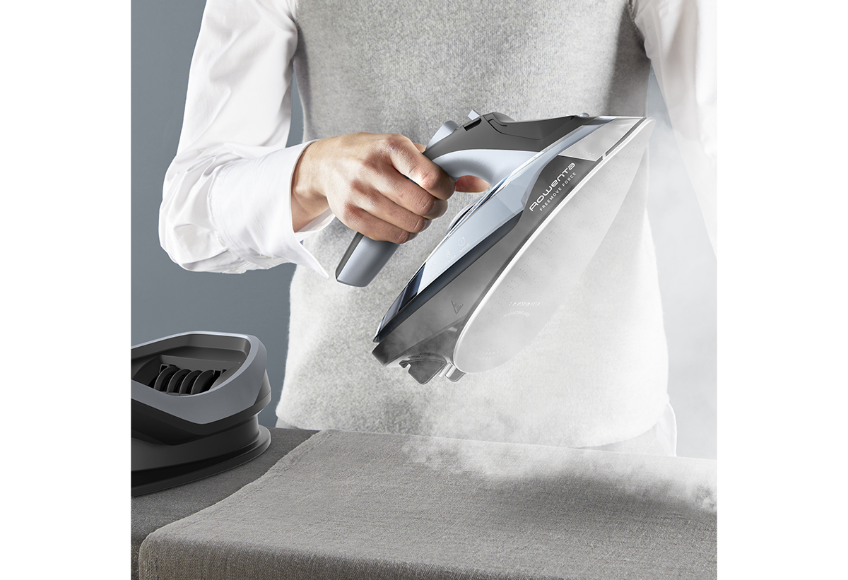 Απεικονίζεται μια γυναίκα να κρατά το σίδερο και να εκτοξεύει ατμό.